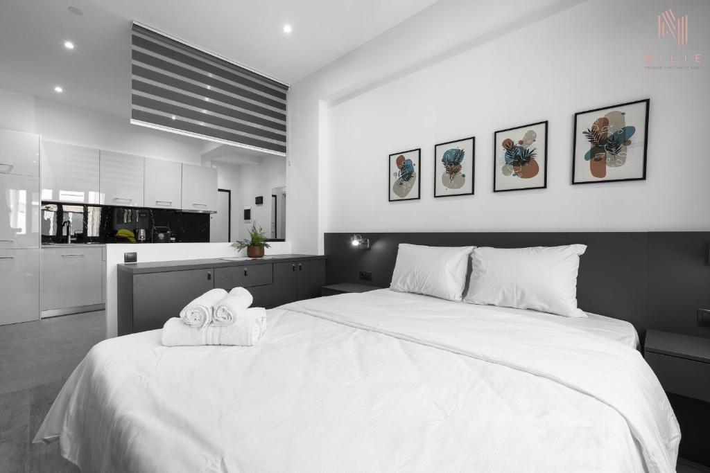 um quarto com uma grande cama branca com toalhas em New Era, Nilie Hospitality MGMT em Tessalônica