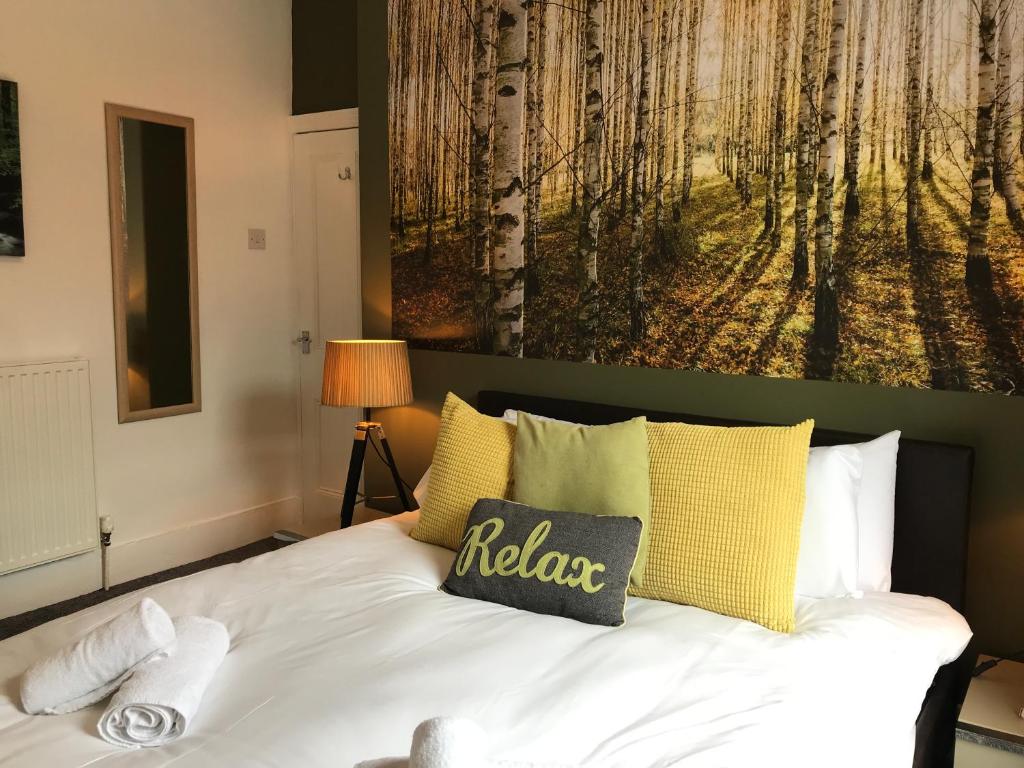 una camera da letto con un letto e un dipinto sul muro di Bright Spacious 3-bed with office & patio, Preston a Preston