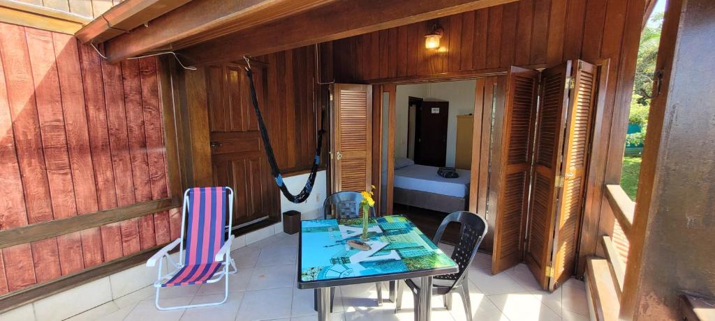Zimmer mit einem Tisch und Stühlen auf einem Balkon in der Unterkunft Casa do Mirante quarto 303 in Florianópolis