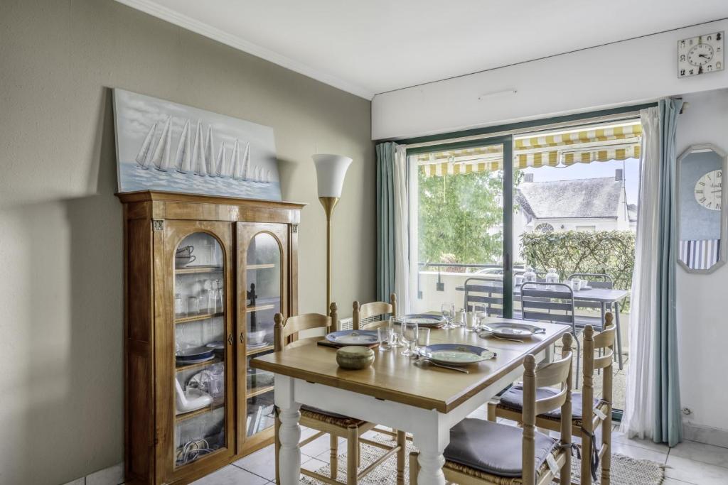 comedor con mesa, sillas y ventana en Charmant appartement lumineux pour 4 personnes au Pouliguen en Le Pouliguen