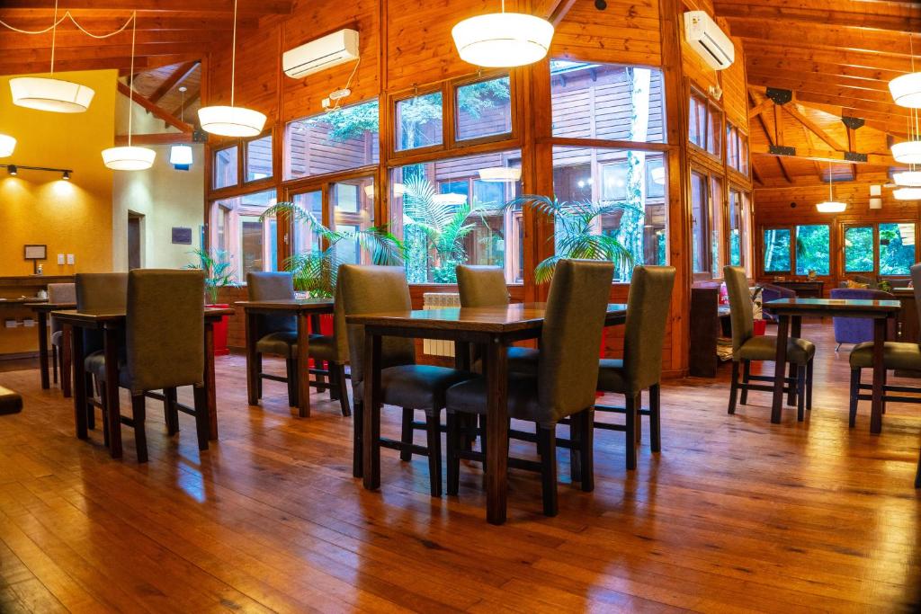 a dining room with tables and chairs and a large window at Selva de Laurel in Puerto Iguazú