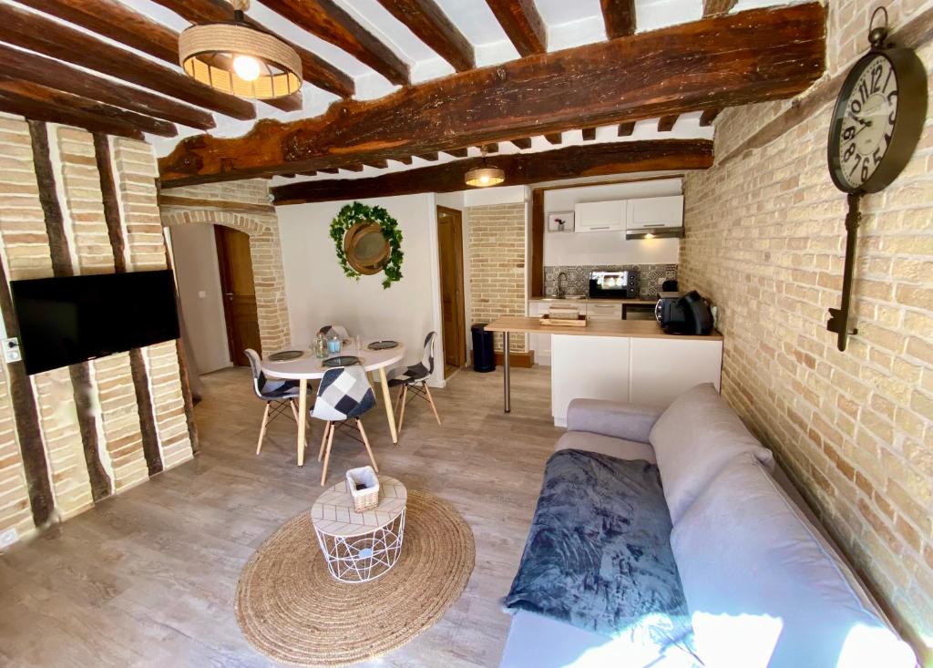 salon z kanapą i zegarem na ścianie w obiekcie Le Confort Normand - Sur les quais & proxy plage - Chaleureux - Full équipé & netflix - Parking gratuit w mieście Dieppe