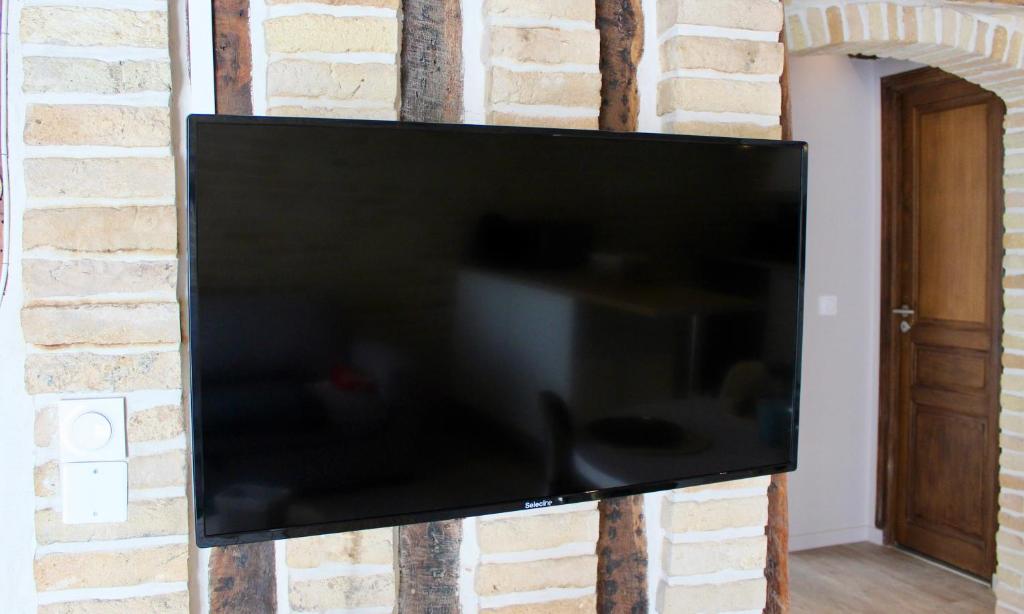 Telewizja i/lub zestaw kina domowego w obiekcie Le Confort Normand - Sur les quais & proxy plage - Chaleureux - Full équipé & netflix - Parking gratuit