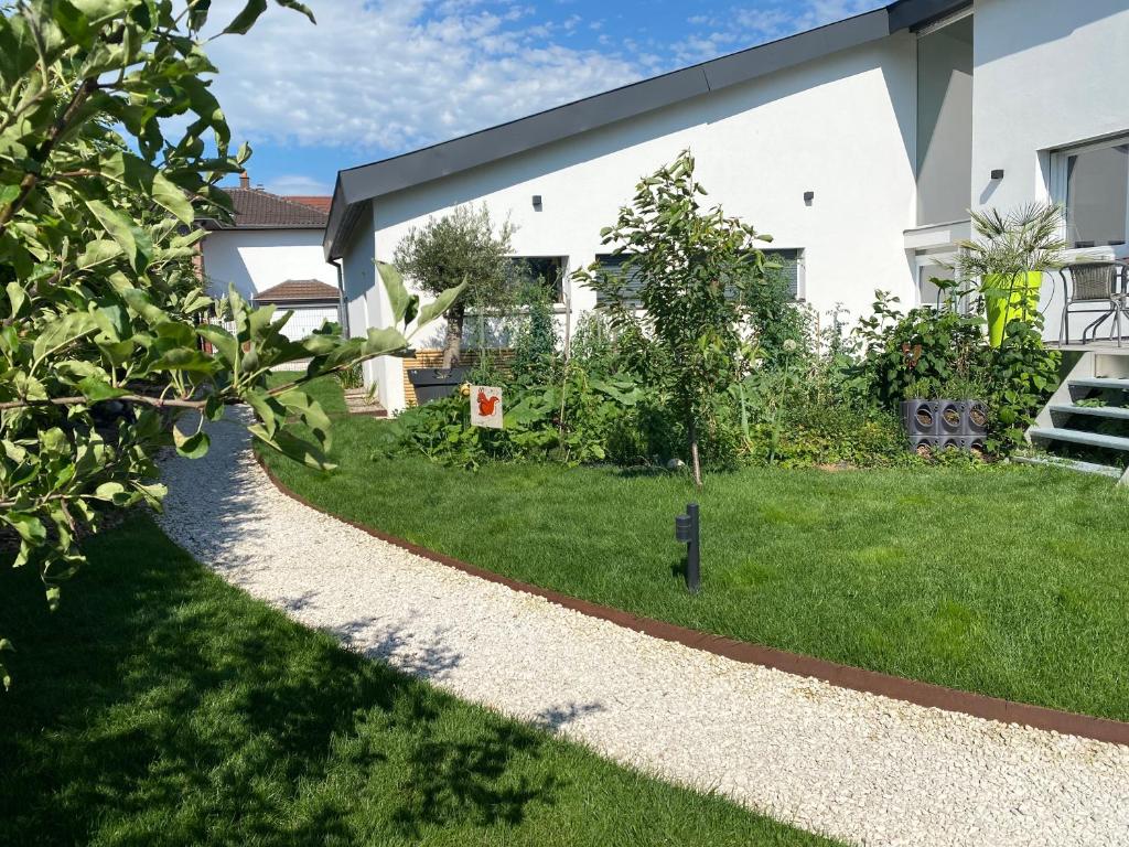 un jardin d'une maison avec une passerelle dans l'établissement Le clos des Pommiers, à Uffholtz