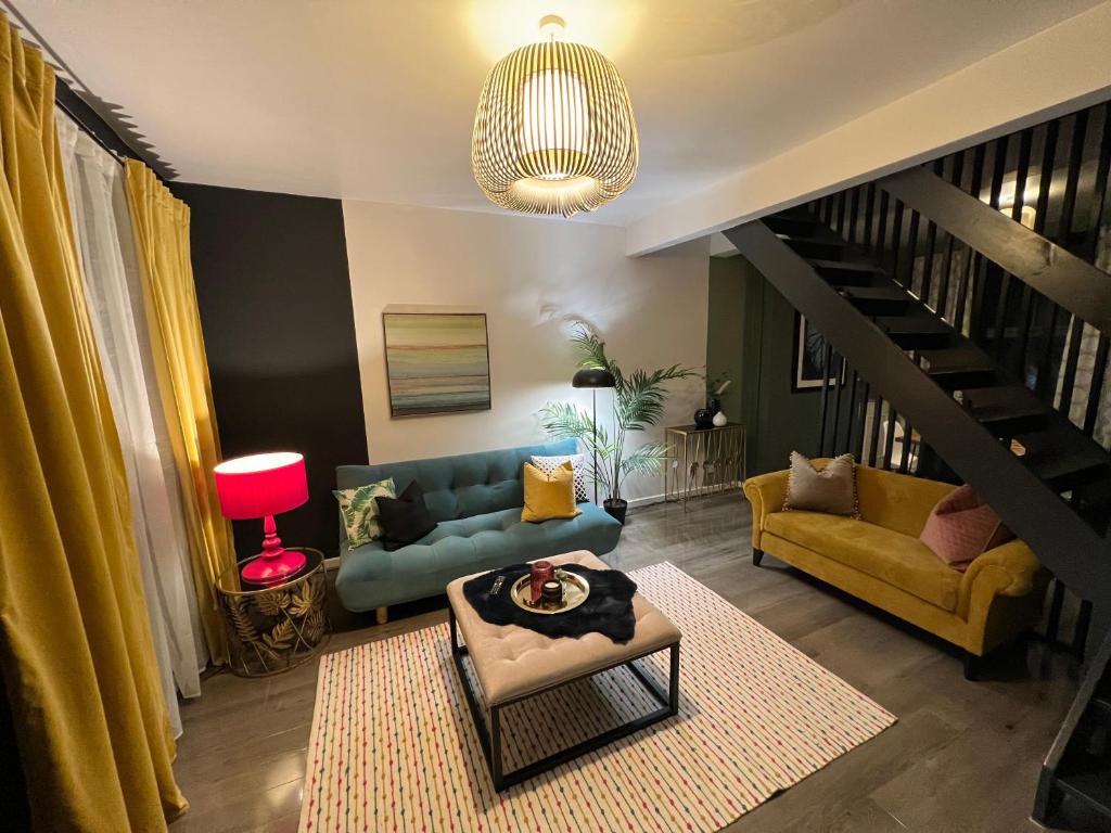 a living room with a blue couch and yellow chairs at City Haven Stylish Home in Manchester