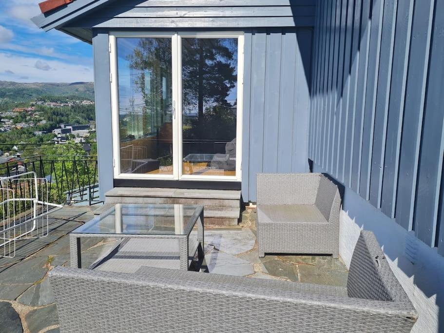 a patio with a glass table and a chair at Beautiful Villa with amazing view in Bergen. in Bergen