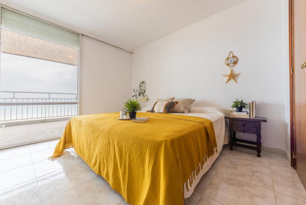 Un dormitorio con una cama con una manta amarilla encima. en HOMES & GO Bell Reco Basic IV, en La Pineda
