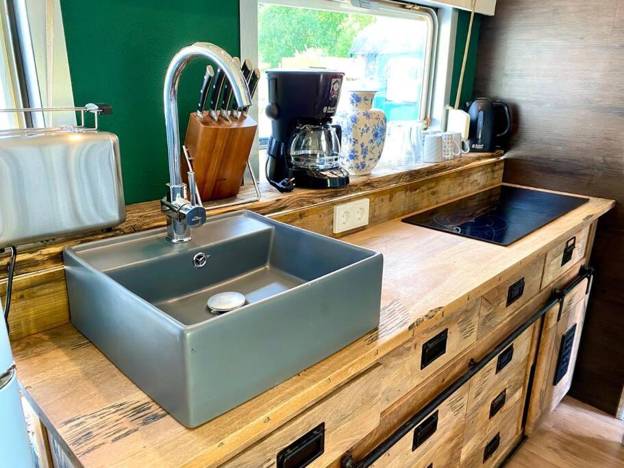 a kitchen with a sink and a counter at Gleis 1, Eisenbahn Waggon mit Whirlpool und Ofen in Dahlem