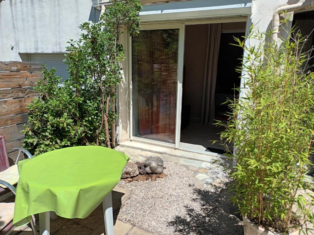 a green chair sitting in front of a door at Chambre raisin 2p, pour 2 nuits max, a 6km du festival de piano de la roque d'anthéron à 100m de la piscine in Rognes