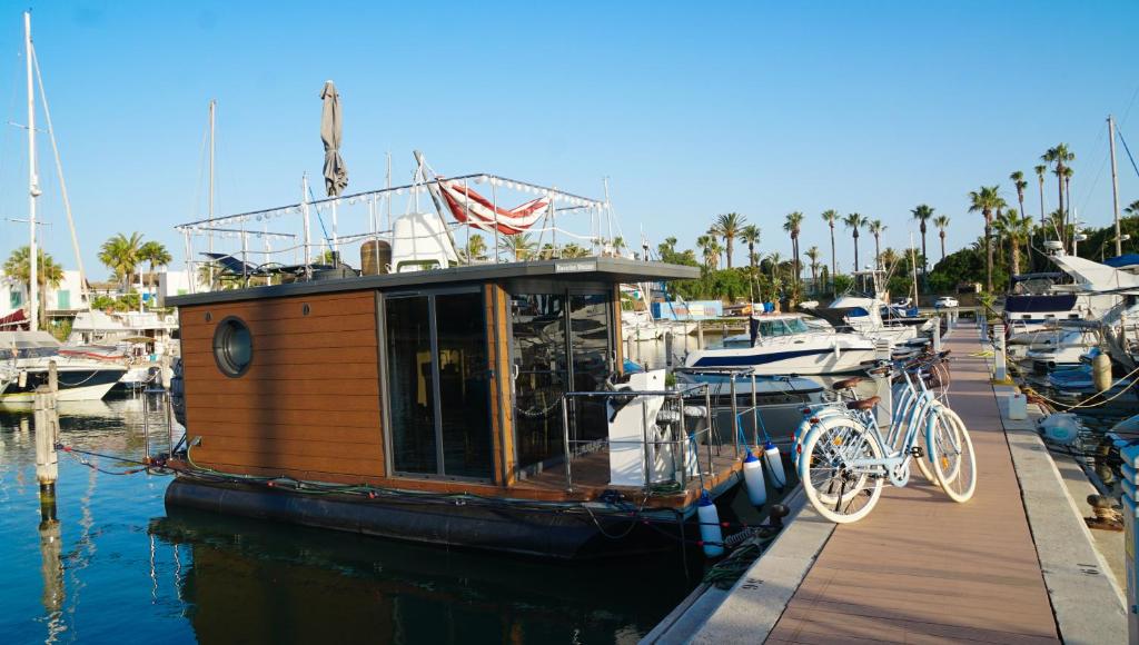 un pequeño barco estacionado en un muelle con una bicicleta en él en La Maison Bateau Sotogrande en San Roque