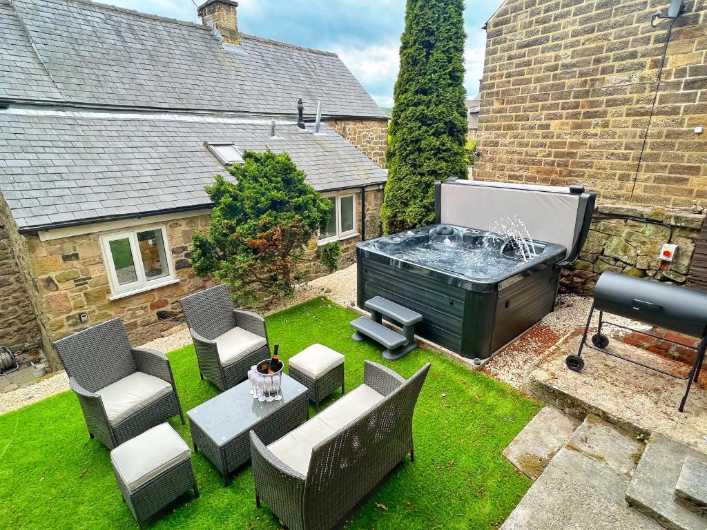 a backyard with a hot tub and a table and chairs at The Old Butchers Cottage in Matlock