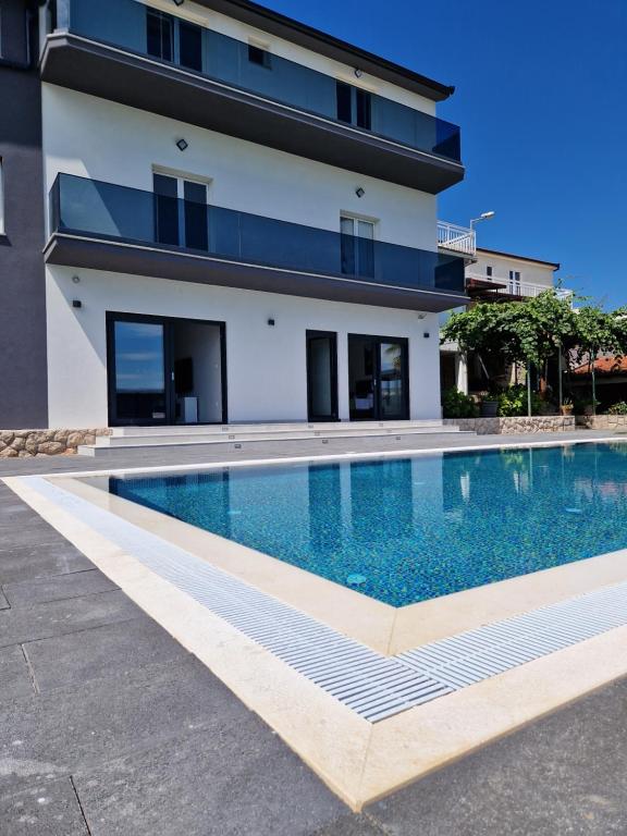 une piscine en face d'un bâtiment dans l'établissement Villa Olea, à Zmijavci