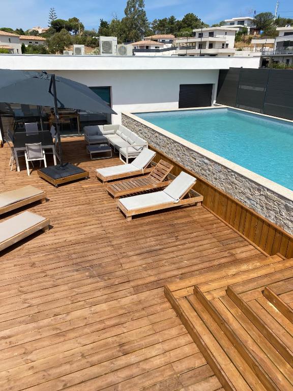 une terrasse avec des chaises et une piscine dans l'établissement Residence LMG 