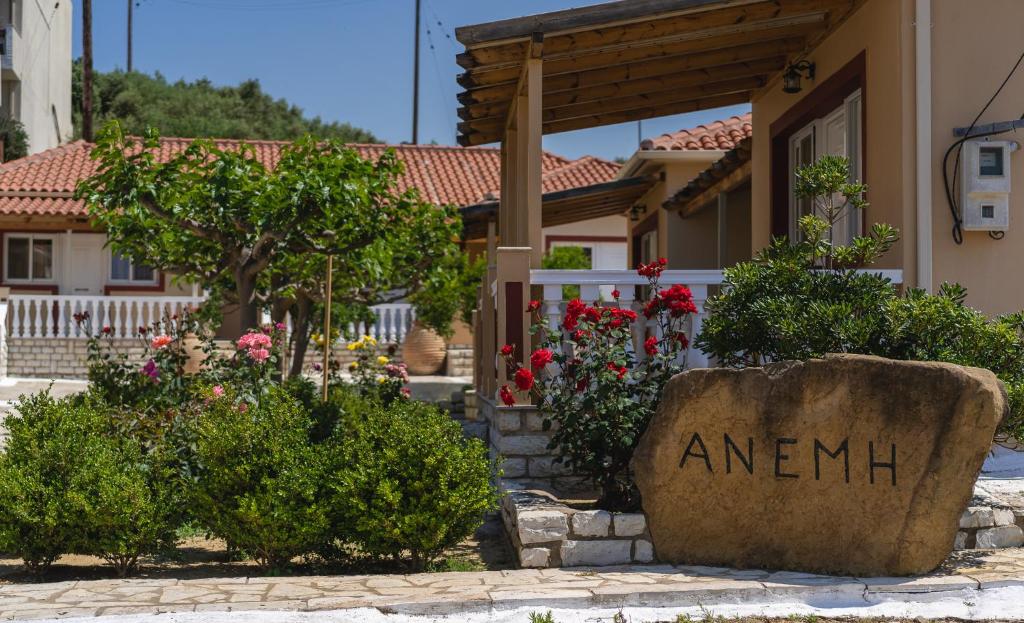 una casa con un cartel que lee amhi delante de un patio en ANEMI APARTMENTs, en Finikounta