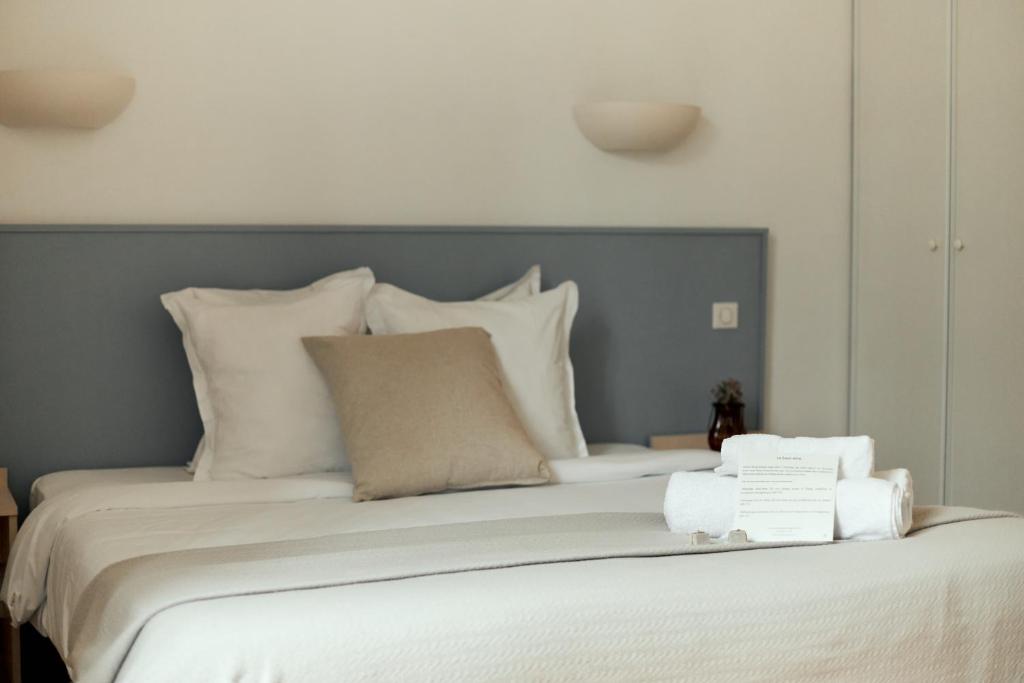 a bed with white pillows and towels on it at La Maison du Gasseau in Saint-Léonard-des-Bois