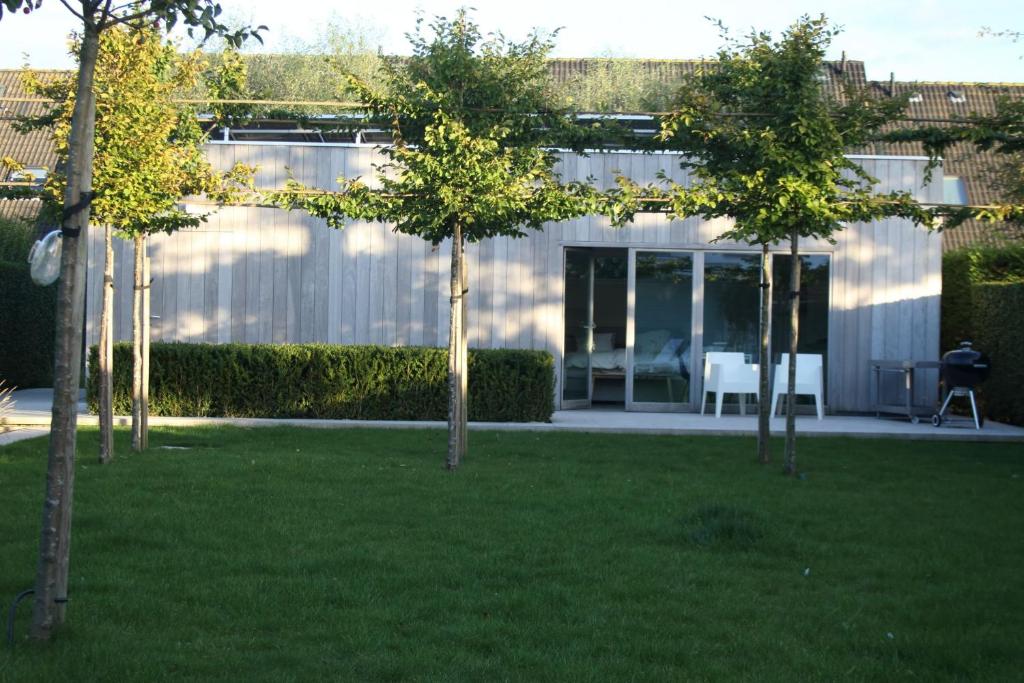 a group of trees in front of a house at Gardenhouse 'The Block' - Ostend - private garden - IR cabine - AC in Ostend