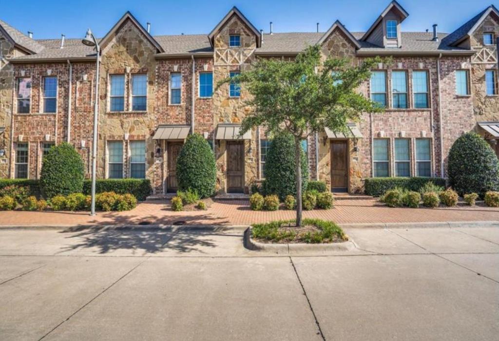 a large brick building with a tree in front of it at Luxury Legacy West Townhouse in Plano