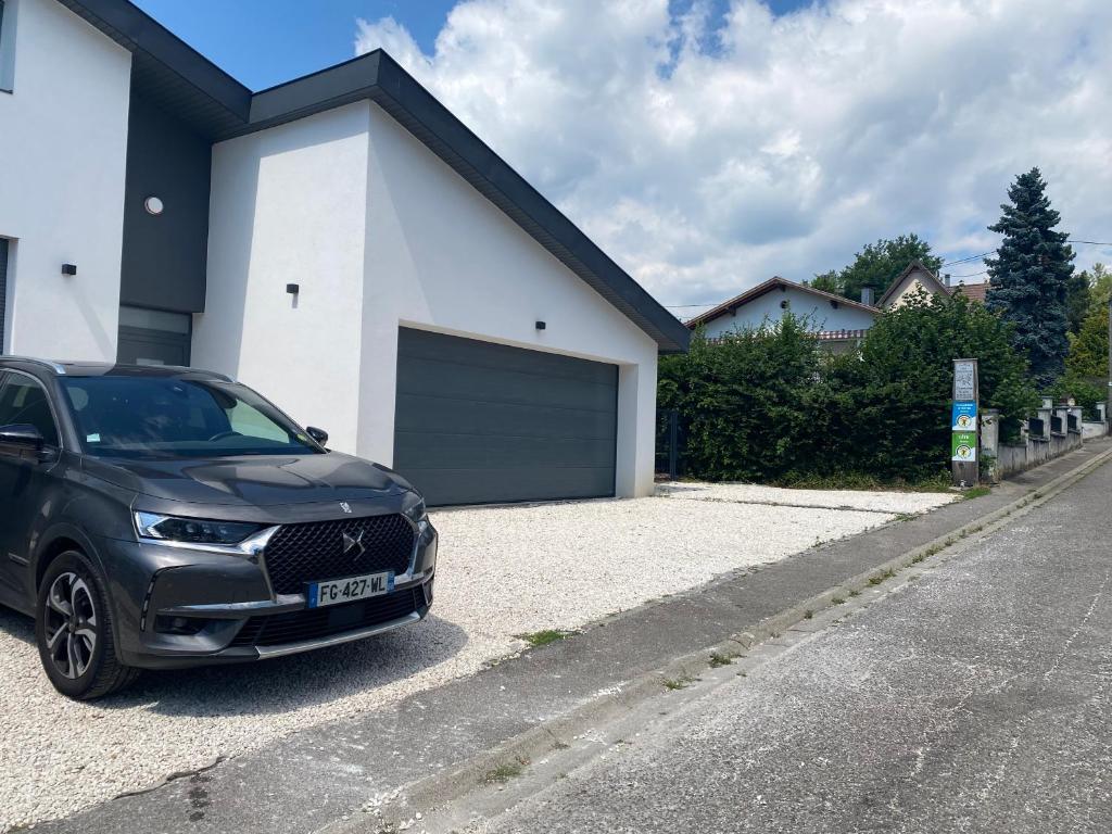 een zwarte auto geparkeerd voor een garage bij Le clos des Pommiers Fuji in Uffholtz