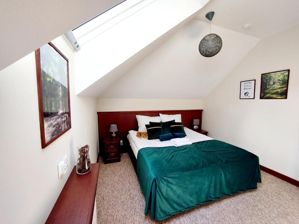 a bedroom with a green bed in a attic at Forrest style Pokoje gościnne in Warszawa