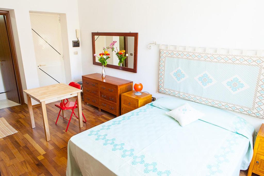 1 dormitorio con cama, mesa y espejo en S Efisio in Cagliari Centre Q4825, en Cagliari
