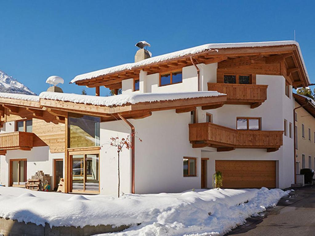 a house with snow on the ground in front of it at Appartement Alpenzauber in Längenfeld