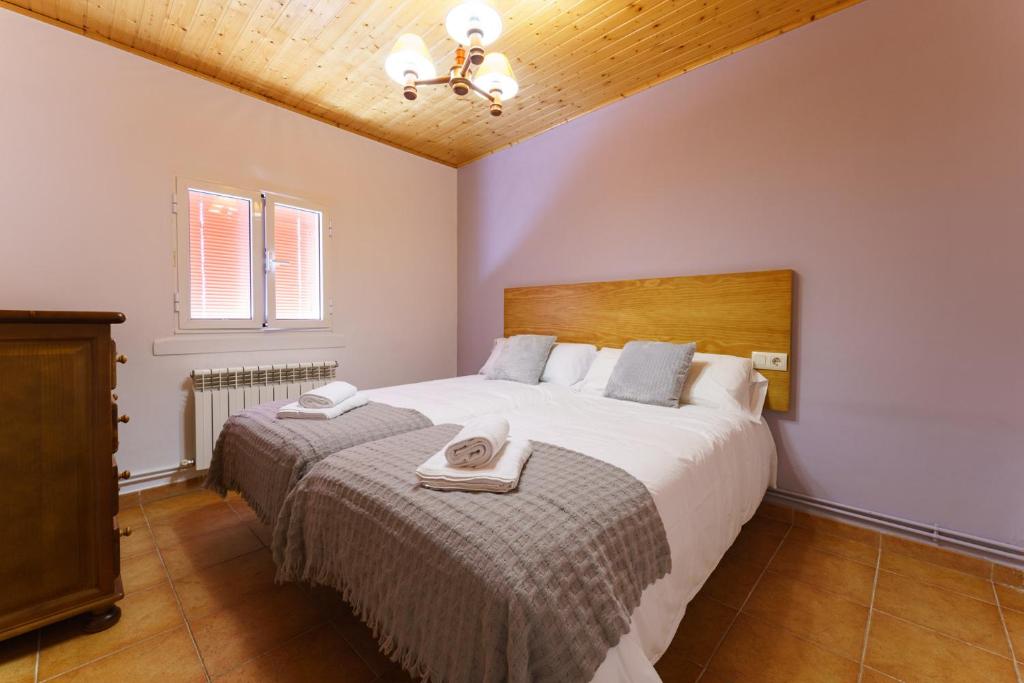 a bedroom with a large bed with two towels on it at O Cubelo in Arzúa