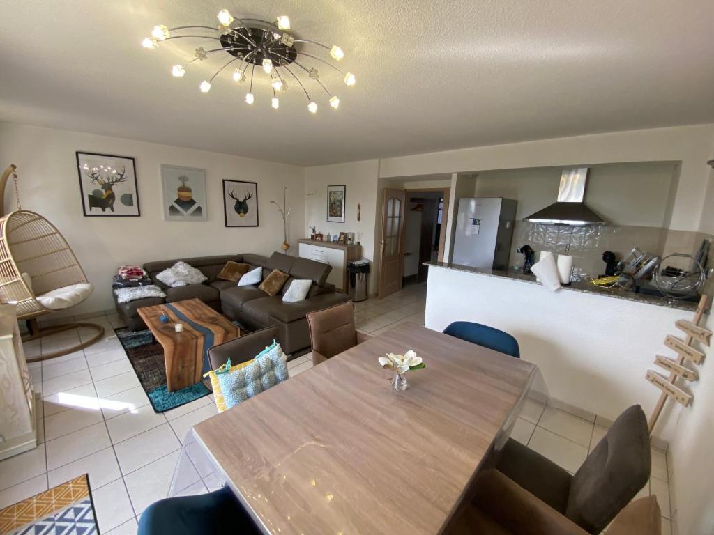 een woonkamer met een tafel en een bank bij Chaleureux appartement T4 cosy, Font Romeu Odeillo Via in Font Romeu Odeillo Via