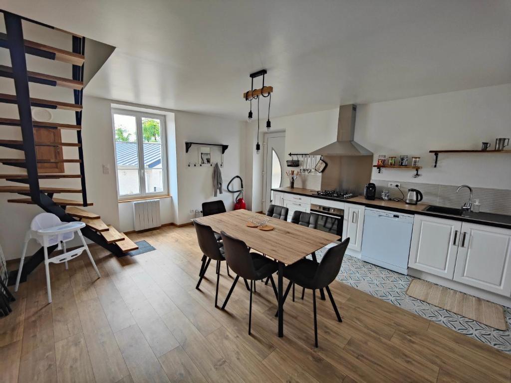 een grote keuken met een houten tafel en stoelen bij L'OASIS - Maison rénovée à 10 min de Beauval in Saint-Romain-sur-Cher