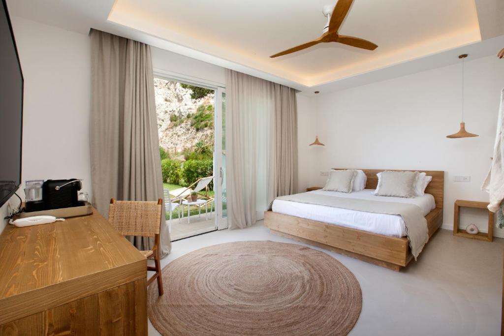 a bedroom with a bed and a large window at Maya Beach Resort in Massa Lubrense