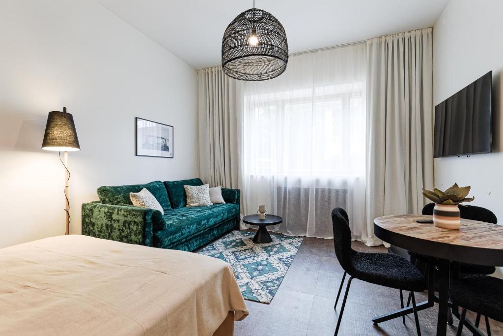 een woonkamer met een groene bank en een tafel bij Old Town Studio Apartment Aia 5a in Tallinn