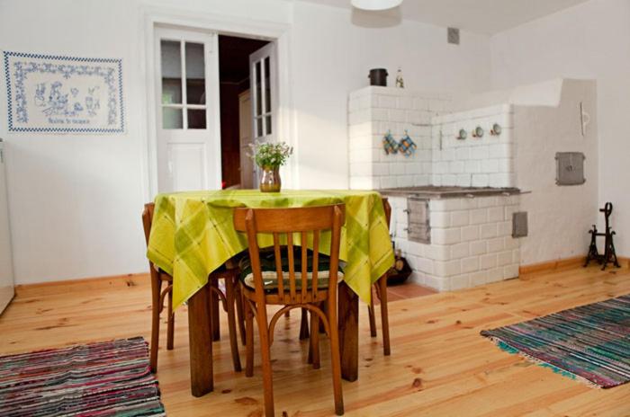 a dining room with a table with a yellow table cloth at Chatka na Roztoczu in Bondyrz