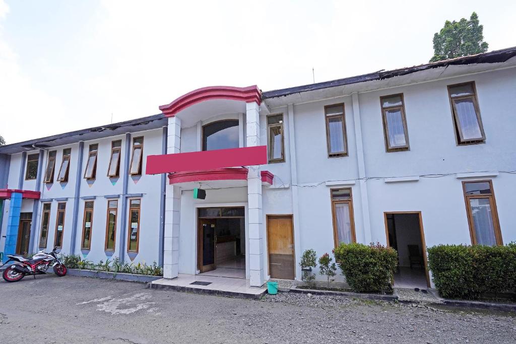 um edifício branco com um sinal vermelho em Super OYO 91350 Garden Hostel em Bandung