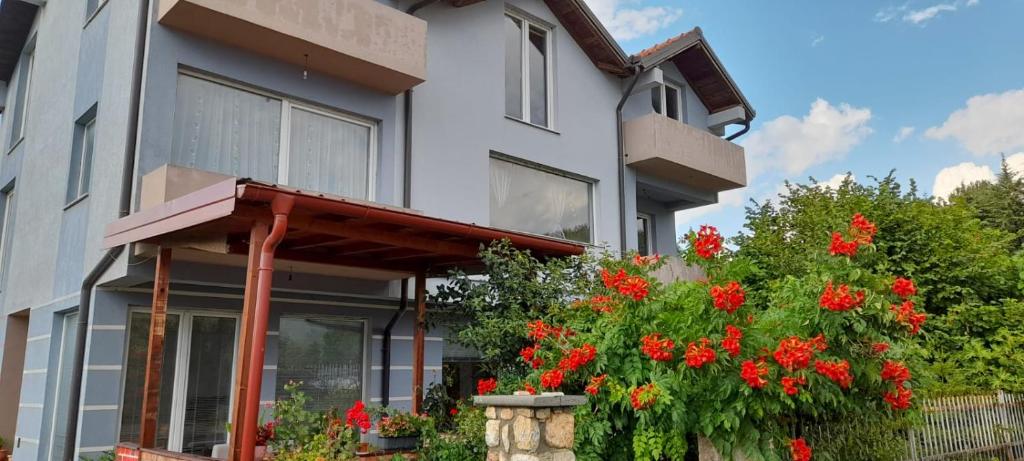 ein Haus mit roten Blumen davor in der Unterkunft Apartments Trpenoski in Ohrid