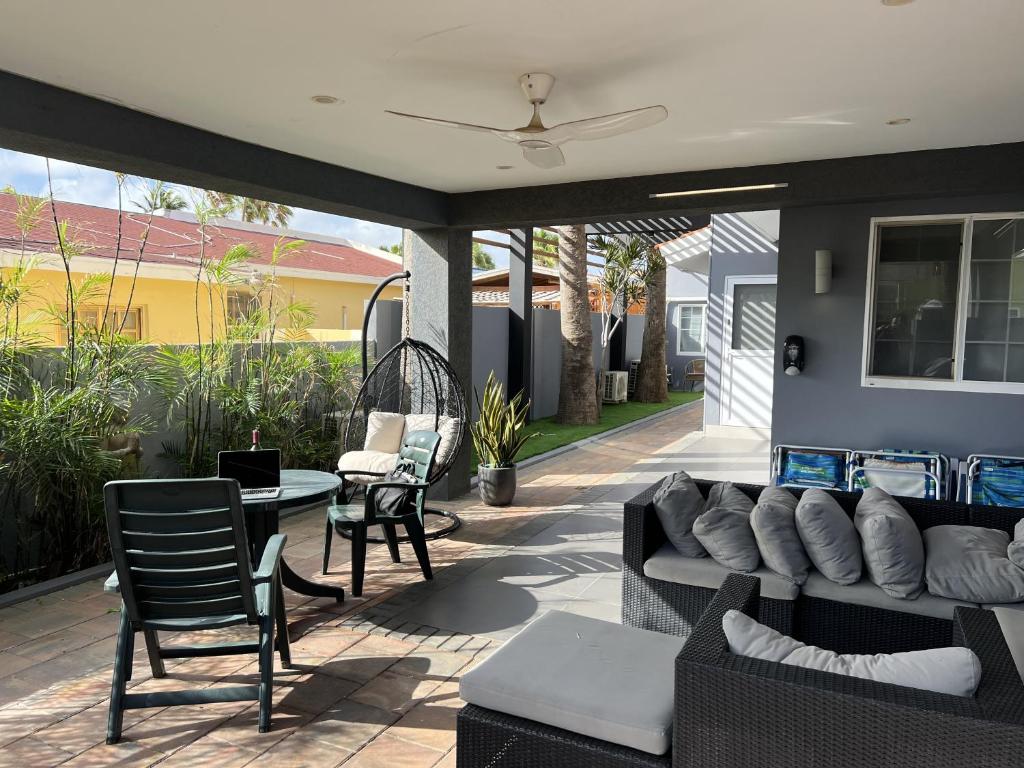 un patio con sofá, mesa y sillas en Brown's 1 Bedroom Apartment, en Palm-Eagle Beach