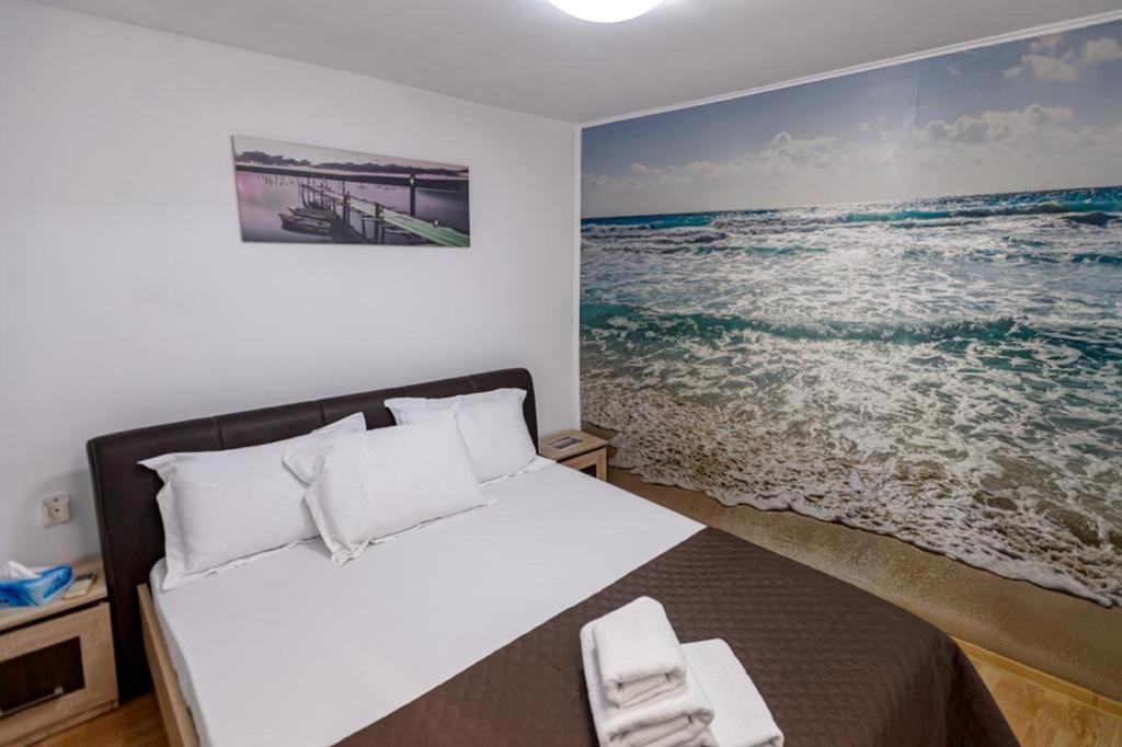 a bedroom with a bed with a picture of the ocean at Casa Maria in Constanţa