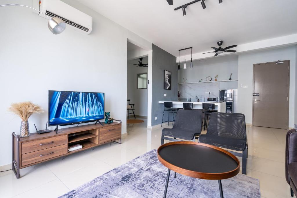 a living room with a television and a table and chairs at Cozy 3-bedroom condo with pool 6 pax - Semarak in Kuala Lumpur