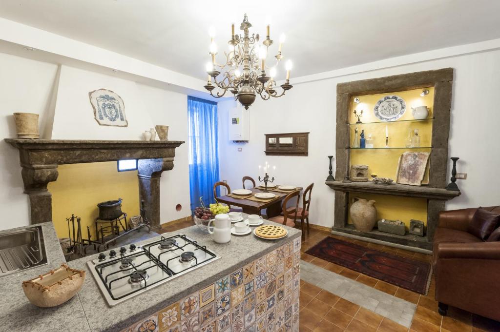 cocina con fogones y sala de estar. en Locazioni Turistiche - Tourist Accomodations - via Schizzaloca 20 - già Residenze Villa Lante, en Viterbo