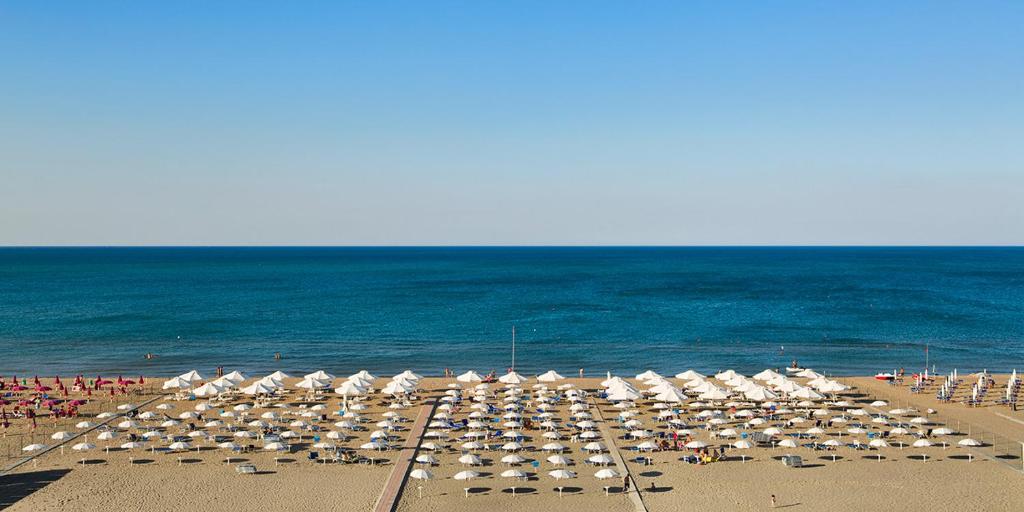 a large group of umbrellas and chairs on a beach at Grand Hotel Terme in Margherita di Savoia