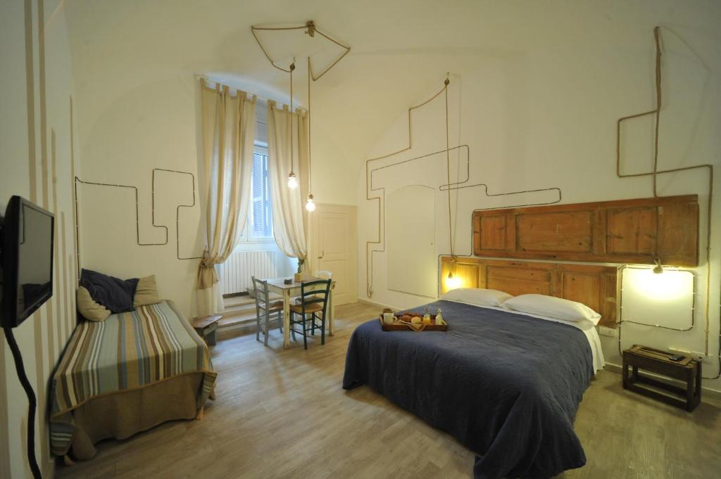 ein Schlafzimmer mit einem Bett, einem Stuhl und einem Tisch in der Unterkunft B&B Zuppetta 16 in Bari