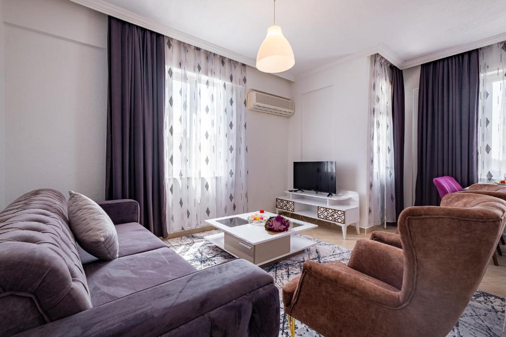 - un salon avec un canapé, des chaises et une télévision dans l'établissement Assos Apart: Havuzlu sitede tamamı sizin 2 oda 1 salon daire, à Belek