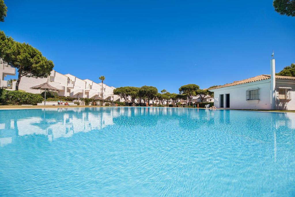 a large pool of blue water next to a building at Pueblo Marinero solo para familias in Chiclana de la Frontera