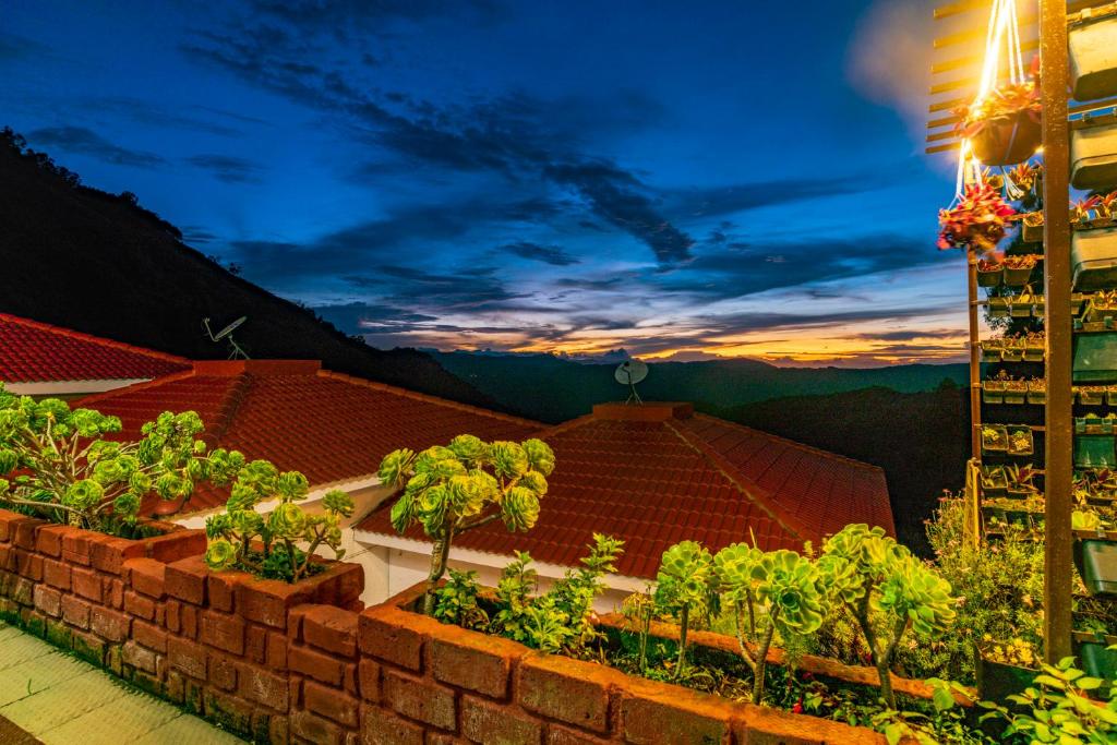 a brick wall with plants on a balcony at night at Warmth Hill Crest in Kodaikānāl