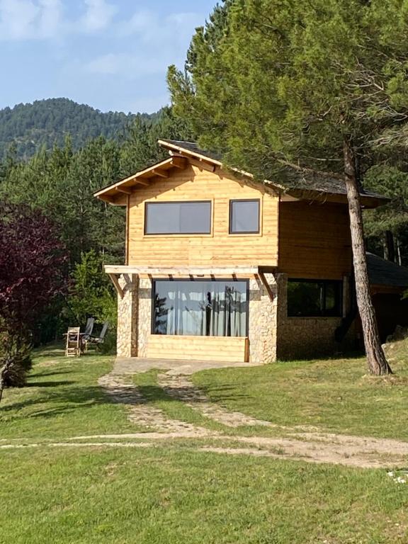 een huis met een groot raam in een tuin bij El Refugi de la Torre Espinalbet in Castellar del Riu