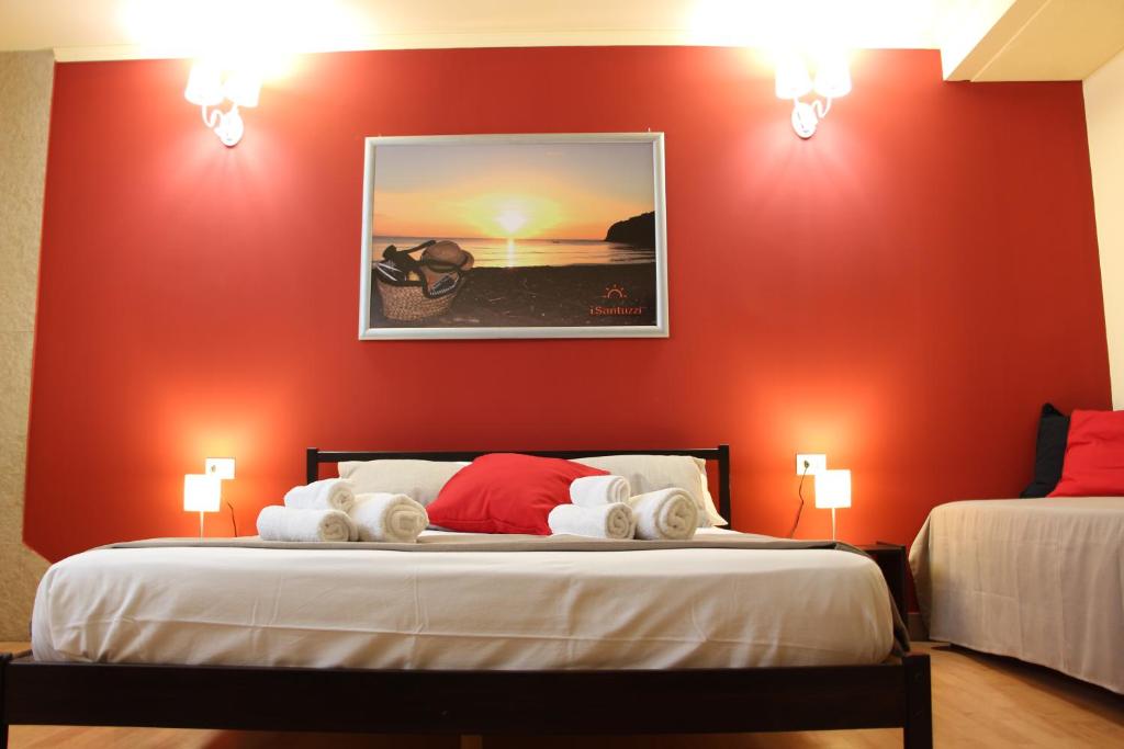 una camera con due letti e una parete rossa di i Santuzzi BeB a Lentini