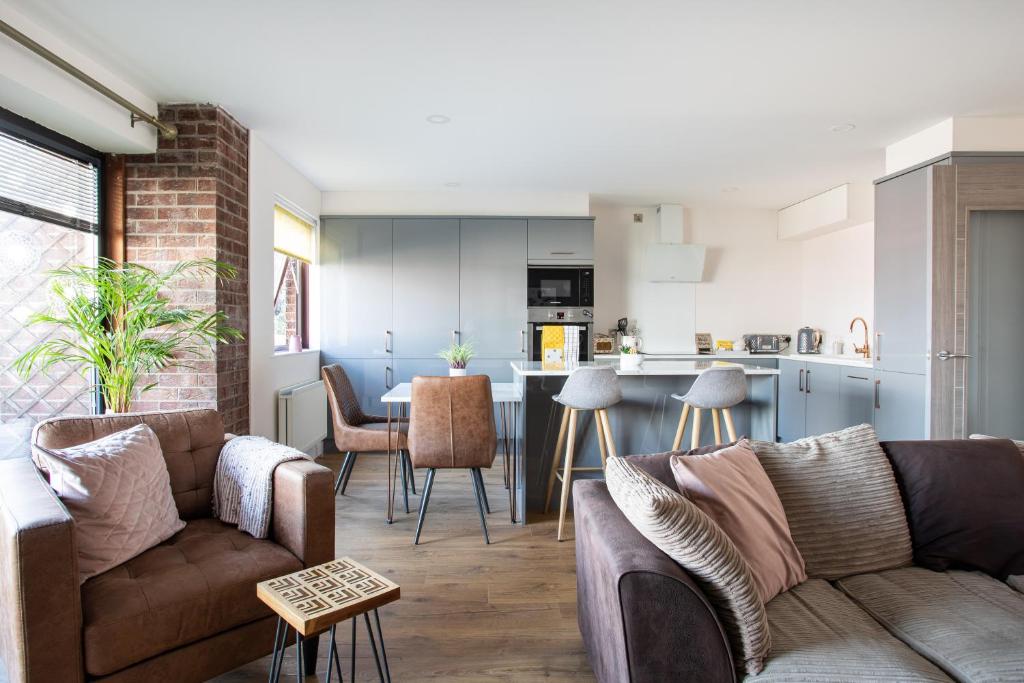 a living room with a couch and a kitchen at New Lisburn Road Apartment - Free Parking in Belfast