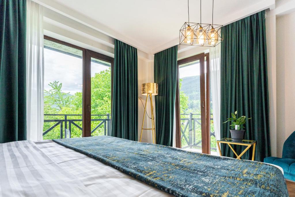 a bedroom with a large bed with a large window at Hotel Chatini Mestia in Mestia