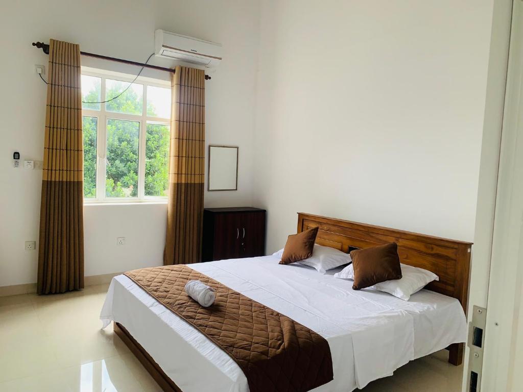 a bedroom with a large bed and a window at Breezy Brand-New Green Tops Villa in Battaramulla