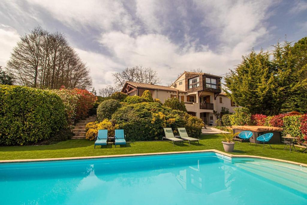 - une piscine en face d'une maison dans l'établissement Belloréade Maison d'hôtes, à Belloc