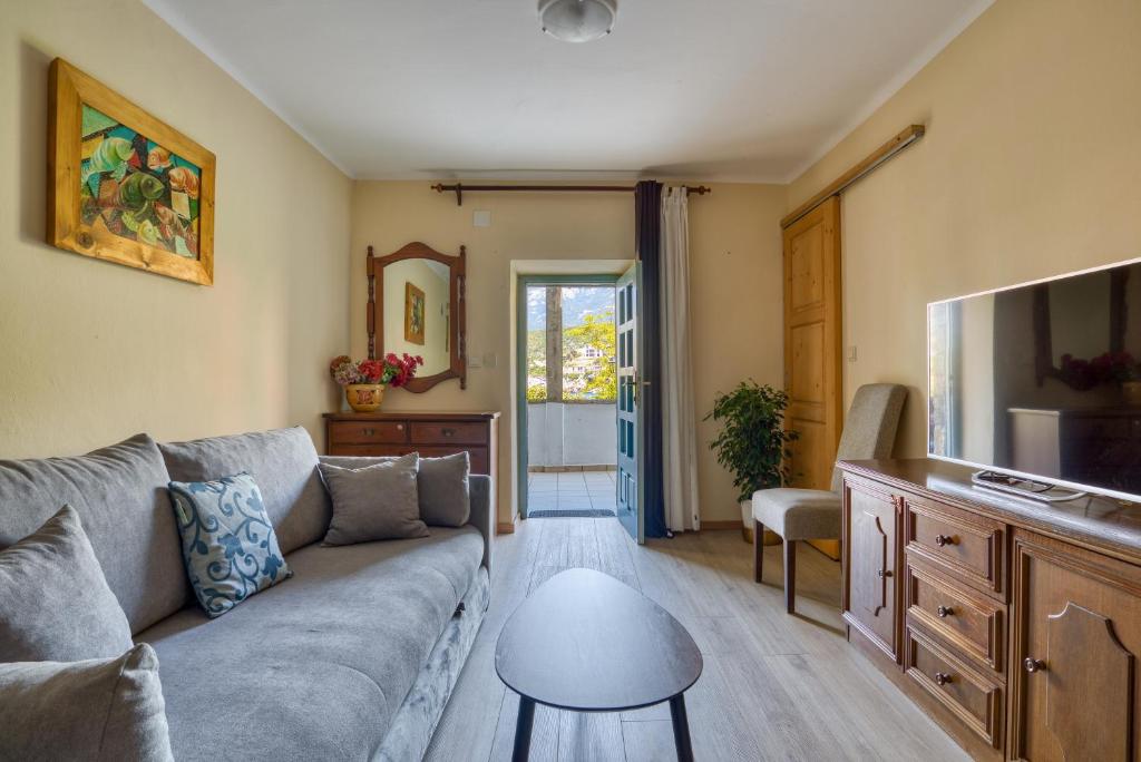 a living room with a couch and a tv at Kazanegra Exclusive Apartments in Sveti Stefan