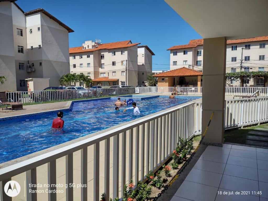 um grupo de pessoas a brincar na piscina de um apartamento em AP VOG PRAIA ILHÉUS BA, Ar Condicionado nos 2 quartos! em Ilhéus